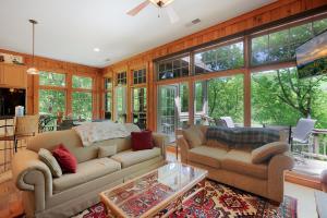 a living room with two couches and a table at - Dawsonville, GA - Take in Beautiful Lake Views, Kick Off a Game of Foosball, Cozy Up by the Fireplace, and Unwind on the Scree in Dawsonville +59 photos