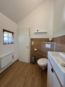 a white bathroom with a toilet and a sink at Naturcamp Duvendiek Blockhäuschen in Niepars