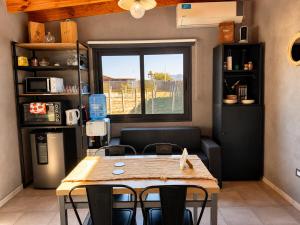 a dining room with a table and chairs and a window at Wine Studio with BBQ & pool in Las Heras