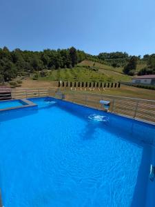 a large pool of blue water next to a fence at Luksuzna kuca sa bazenom 