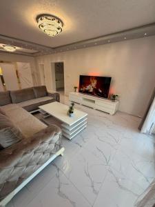 a living room with a couch and a fireplace at Luksuzna kuca sa bazenom 