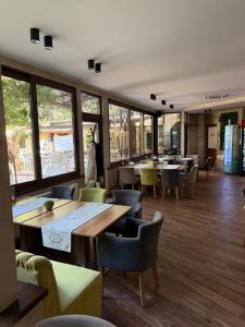 a restaurant with tables and chairs and windows at Motel Eros in Sandanski