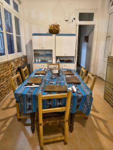 a dining room with a table with chairs and a kitchen at Hostal LA BLANQUITA in San Fernando del Valle de Catamarca