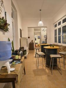 a living room with tables and stools and a kitchen at Hostal LA BLANQUITA in San Fernando del Valle de Catamarca