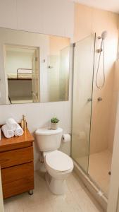 a bathroom with a toilet and a glass shower at Tu refugio ideal cerca al mar in Playa Bello Horizonte