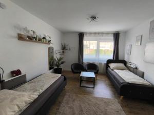 a living room with two beds and a table at 4 You Apartment in Leoben mit Balkon, Garten und kostenlosen Parkplatz in Leoben