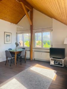 a living room with a table and a tv at Stilvolles Loft-Apartment in Gais