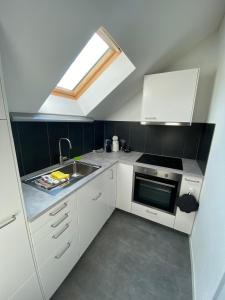 a small kitchen with a sink and a skylight at Stilvolles Loft-Apartment in Gais
