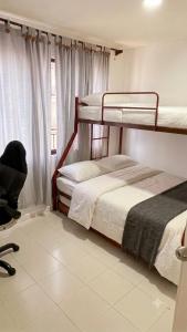 two bunk beds in a room with a window at Tu refugio ideal cerca al mar in Playa Bello Horizonte