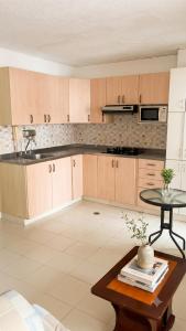 a kitchen with wooden cabinets and a table in it at Tu refugio ideal cerca al mar in Playa Bello Horizonte