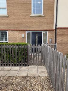 a wooden fence in front of a building at Delwin Place - Quiet Stay & Sparkling Bathroom in Dunstable