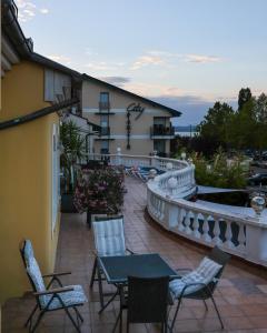 a balcony with chairs and tables and a building at Y Panzió in Balatonlelle