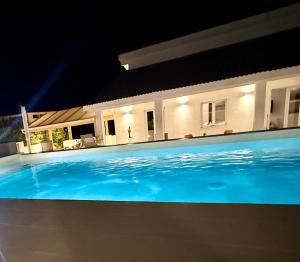 a swimming pool in front of a house at night at Gegè Relais in San Corrado di Fuori