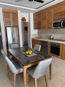 a kitchen with a wooden table with chairs and a tableasteryasteryasteryasteryastery at Santa Cruz Condo in Santa Cruz Huatulco +4 photos