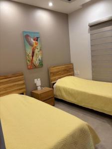 a room with two beds and a painting on the wall at Santa Cruz Condo in Santa Cruz Huatulco