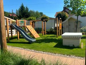 a playground with a slide in a yard at Domki u Oli in Stegna