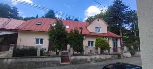 a house with a red roof on a street at Apartmán Domča in Banská Štiavnica