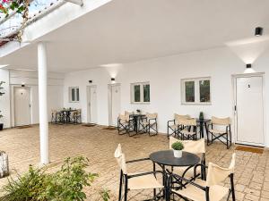 a large white room with tables and chairs at Coconut Beach Villas 2 in Panayía Mesosporítissa