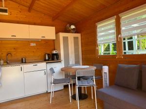 a kitchen with a table and chairs in a cabin at Domki u Oli in Stegna