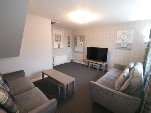 a living room with two couches and a flat screen tv at Superhost House Brechin sleeps 6, 3 bedrooms in Brechin