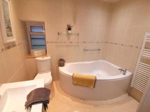 a bathroom with a white tub and a toilet at Superhost House Brechin sleeps 6, 3 bedrooms in Brechin +10 photos