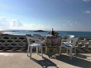 uma mesa e cadeiras com uma garrafa de vinho na praia em Villino Fascinoso by Holiday World em Granelli