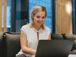 a woman sitting in front of a laptop computer at Hotel ibis Lisboa Saldanha in Lisbon