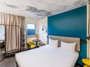 a bedroom with a white bed and a blue wall at Hotel ibis Lisboa Saldanha in Lisbon +151 photos