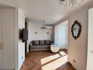 a living room with a couch and a mirror at Gorgeous view apt riscanovca in Chişinău