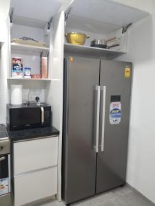 a kitchen with a refrigerator and a microwave at Eden Heights in Tokuse