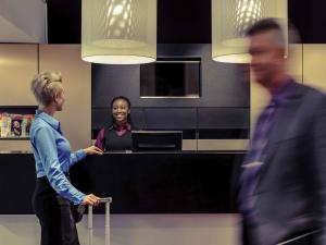 a woman standing at a desk in an office at Congress Hotel Mercure Nürnberg an der Messe in Nuremberg