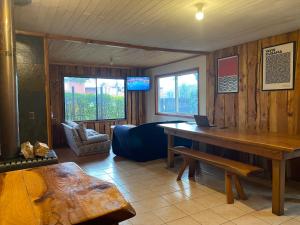 a living room with a wooden table and a couch at Hostel Raíz Del Pillán in Pucón