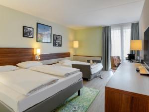 Mercure Stuttgart Sindelfingen an der Messe في شيندلفينجن: غرفة فندق بها سريران ومكتب