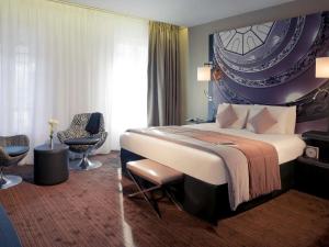 a hotel room with a large bed and a chair at Mercure Lyon Centre Beaux-Arts in Lyon