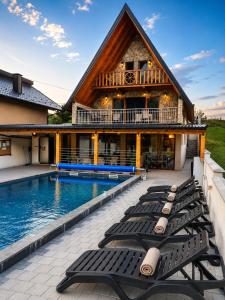 a row of chaise lounges next to a house at Vikendica Vesic Tegare in Bratunac