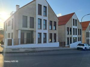 a row of houses with a car parked in front of them at Ático en Ribeira Ría de Arousa in Ribeira