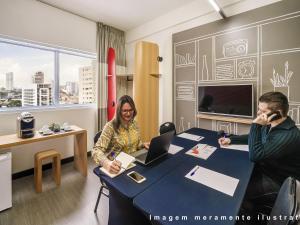 a man and a woman sitting at a table with a laptop at ibis Styles Curitiba Centro Civico in Curitiba +75 photos