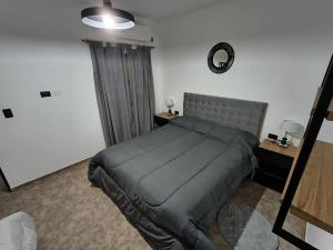 a bedroom with a bed and a clock on the wall at Alojamiento Pasaje Montes in Cruz del Eje