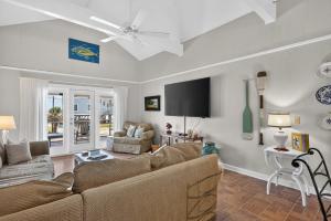 a living room with a couch and a flat screen tv at The Edistoneyan in Edisto Island +55 photos