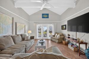 a living room with a couch and a tv at The Edistoneyan in Edisto Island