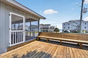 a wooden bench sitting on the deck of a building at The Edistoneyan in Edisto Island