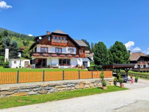 a large house with a fence in front of it at Ferienhaus Bernadette in Mauterndorf