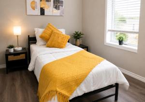 a bedroom with a bed with a yellow blanket on it at Southside Haven Edmonton in Edmonton