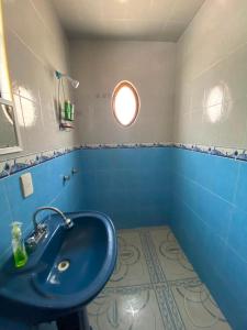 a bathroom with a blue sink and a window at Hospedaje Daki in Zacatlán
