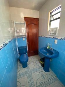 a bathroom with a blue toilet and a sink at Hospedaje Daki in Zacatlán