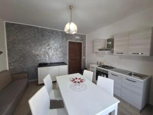 a kitchen with a white table and white chairs at Casa mariano in Marconia