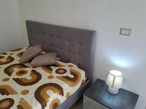 a bedroom with a bed and a lamp on a table at Casa mariano in Marconia +6 photos