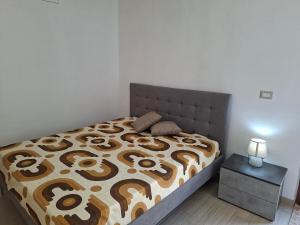 a bedroom with a bed with a brown and white comforter at Casa mariano in Marconia