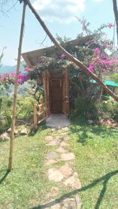a small house with a wooden door with flowers at Cabañas la pradera in Ruiosucio +6 photos