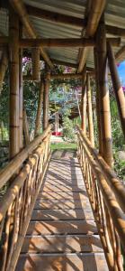 a wooden bridge in a park with a wooden roof at Cabañas la pradera in Ruiosucio